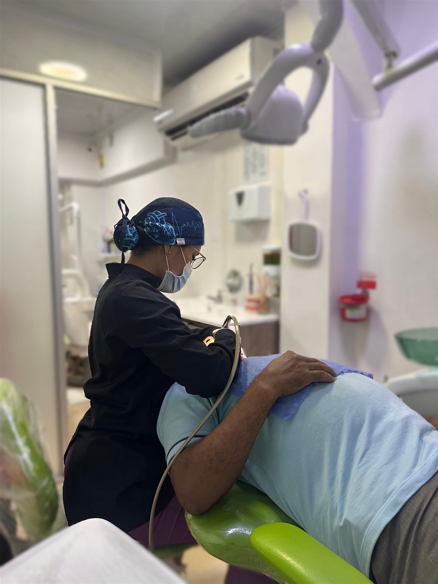 Profesional de Sonri-Pluss atendiendo a un paciente en el consultorio.